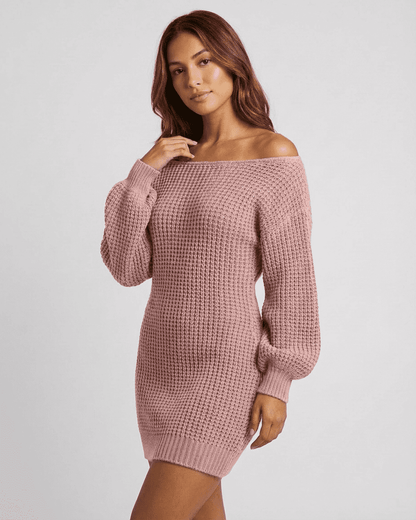 Model wearing a pink Nova Mini Dress by SLIMONA with ribbed knit and off-the-shoulder design.