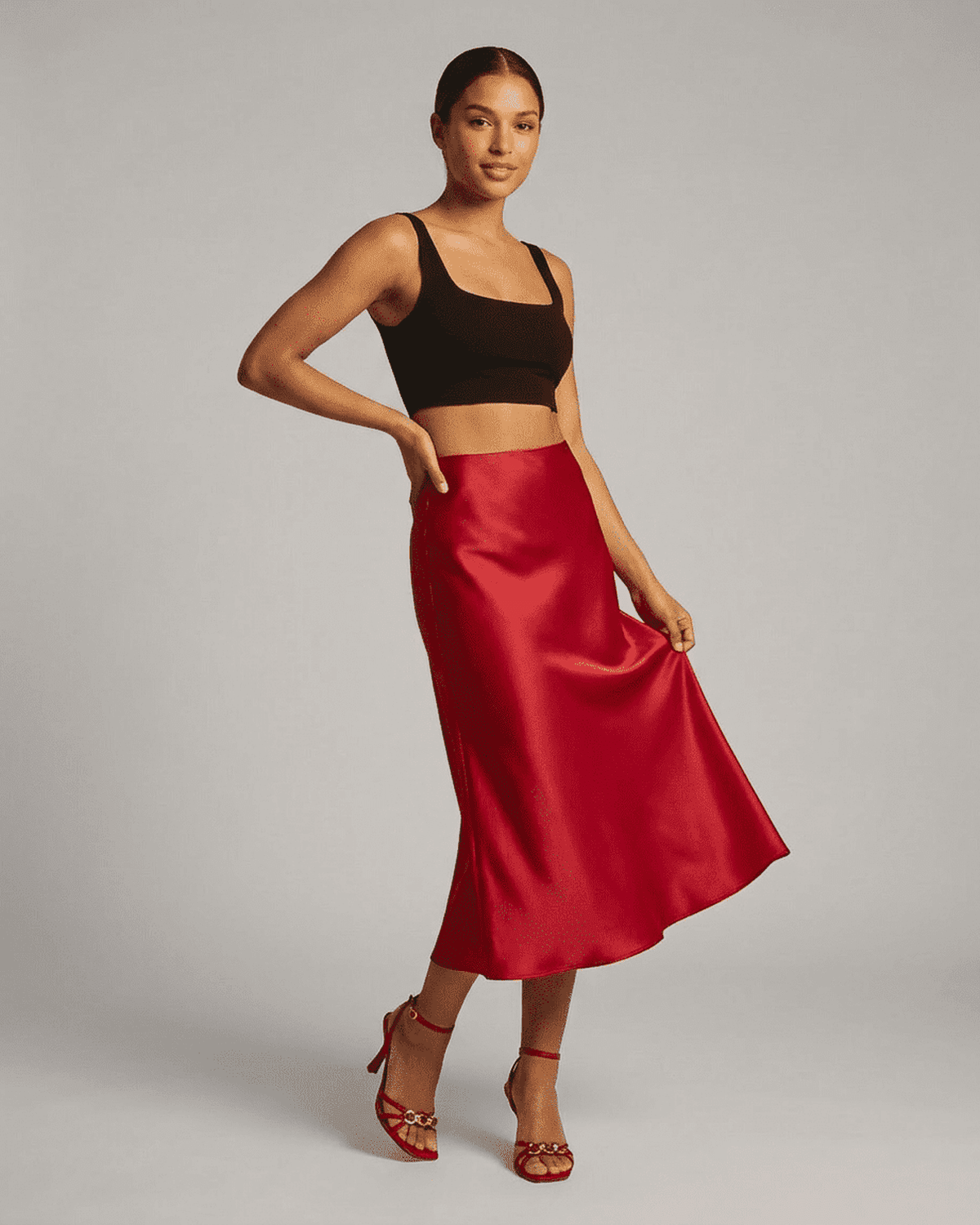 Model wearing the Rosalia Midi Skirt by SLIMONA, showcasing its elegant red satin mermaid design.