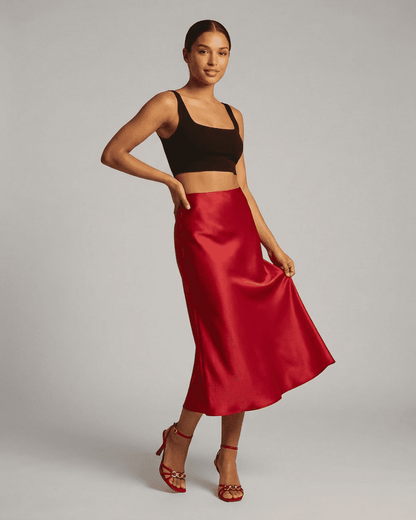 Model wearing the Rosalia Midi Skirt by SLIMONA, showcasing its elegant red satin mermaid design.