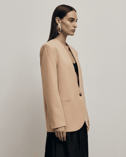 Savona Blazer by SLIMONA, a women’s beige tailored blazer with a fitted single-breasted design and deep V-neckline.
