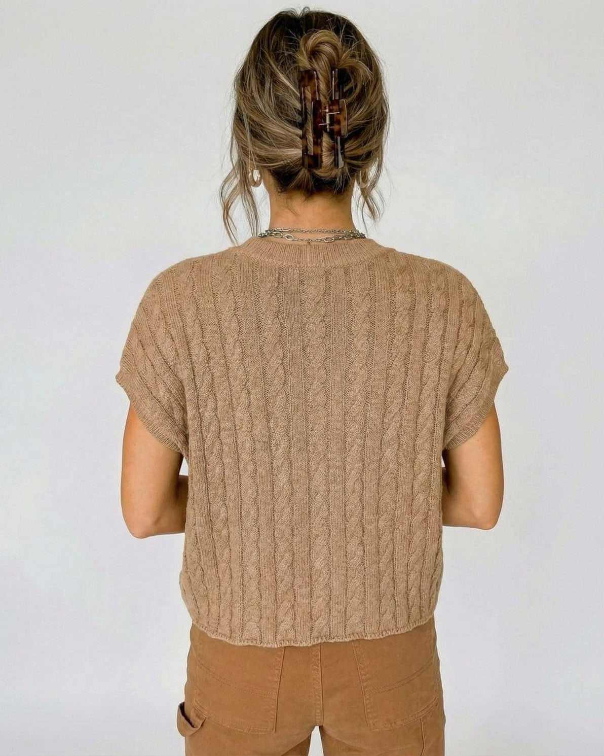 Back view of a model in a Toscana Sweater by Lauven, showcasing the cable knit design and relaxed fit.