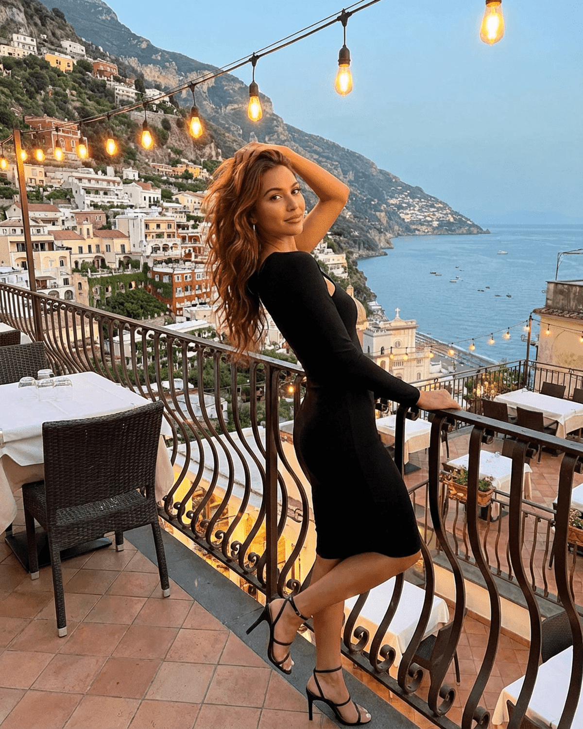 Vega Midi Dress by SLIMONA showcased on a model at a beautiful coastal outdoor restaurant.