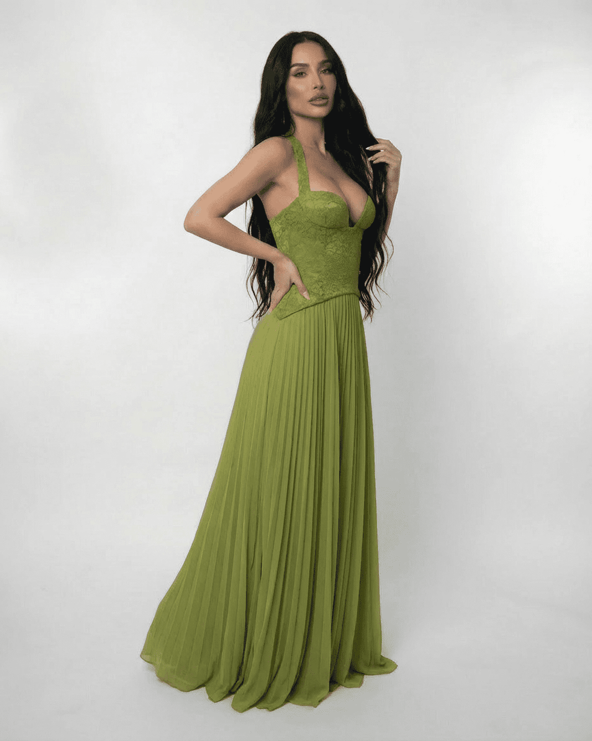 Model showcasing the SLIMONA Verdant Maxi Dress with a lace bodice and pleated skirt in olive green.