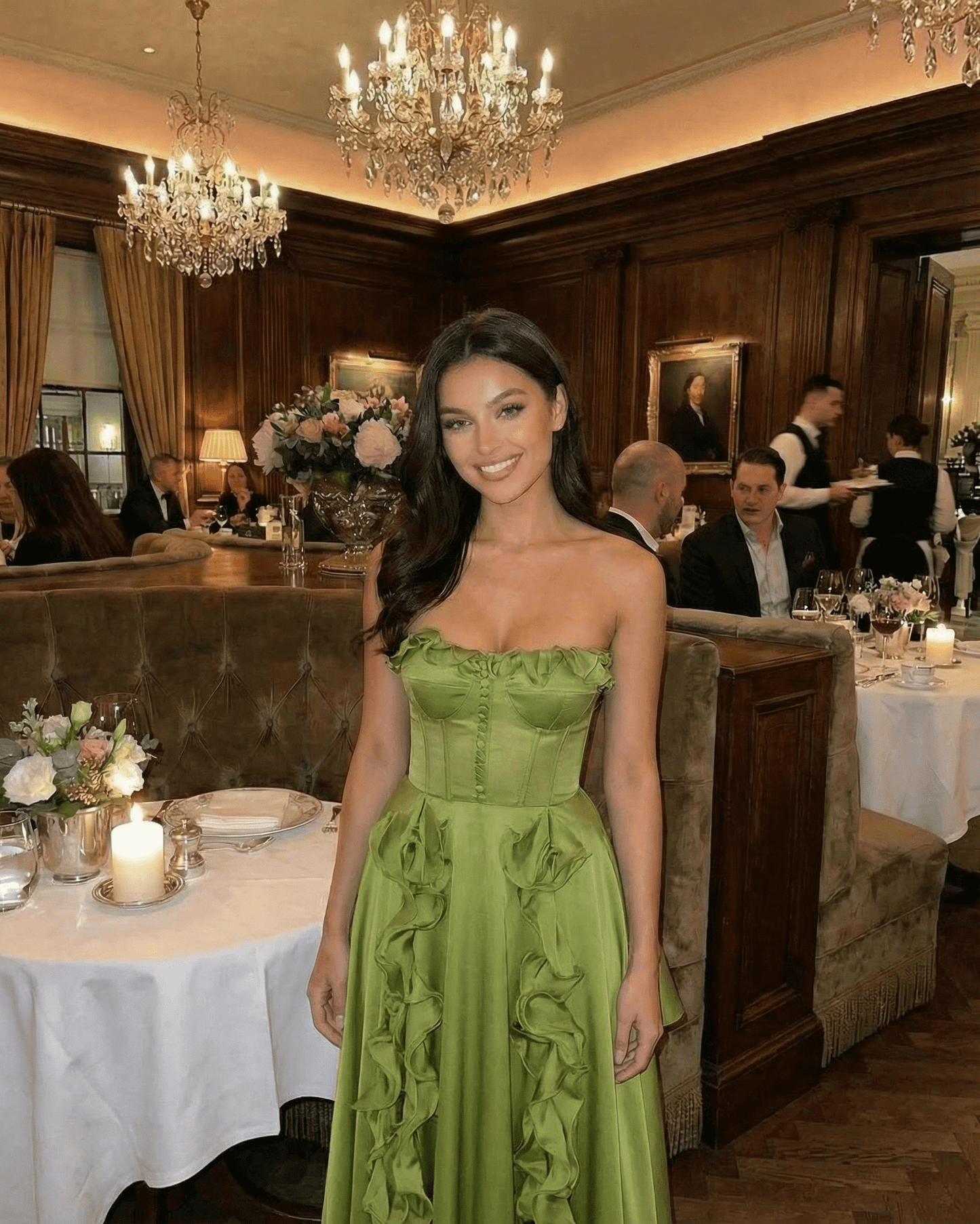 Model wearing Verdessa Maxi Dress by SLIMONA in elegant restaurant setting with ruffle detail in green.