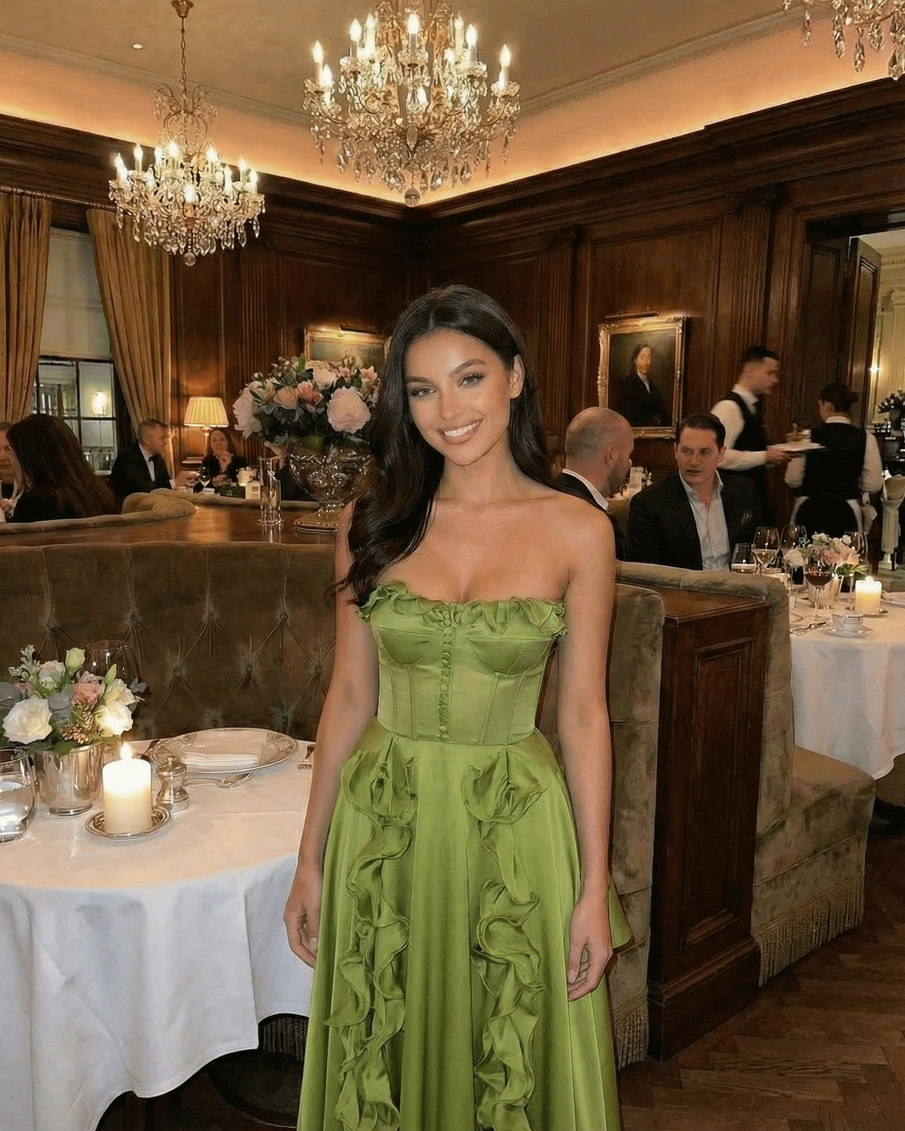 Model wearing Verdessa Maxi Dress by SLIMONA in elegant restaurant setting with ruffle detail in green.