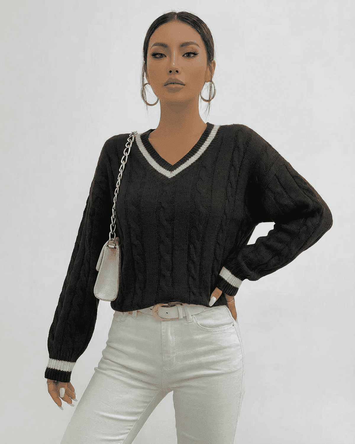 Model wearing a SLIMONA Verona Sweater cable knit V-neck pullover in black with white trim.